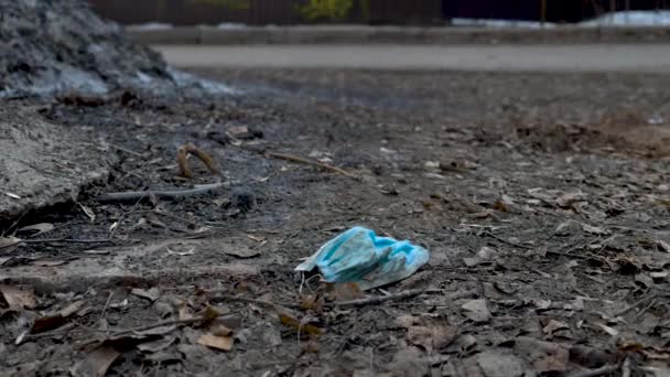 Schieten van gebruikte medische masker op de grond — Stockvideo