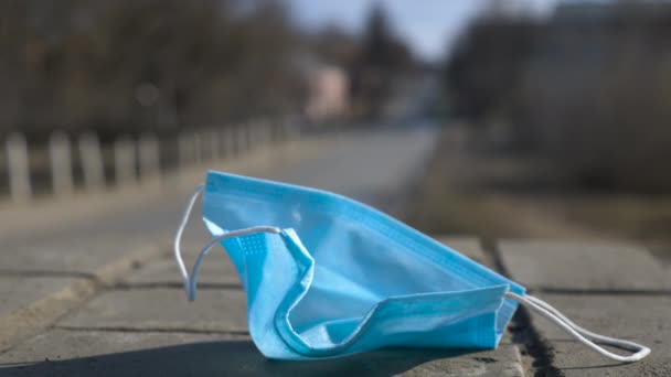 Видео использованной защитной маски у дороги — стоковое видео