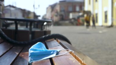Shooting of used medical mask on the wooden bench