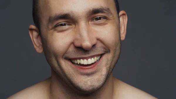 Фото улыбающегося взрослого мужчины брюнетки на сером — стоковое фото