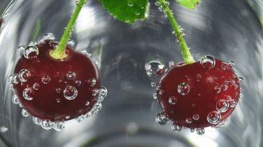 Olgun vişne ve su kabarcıklarının fotoğrafı.