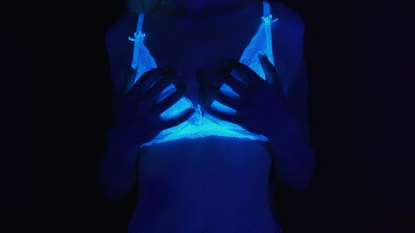 Zdjęcie dwóch kobiet dotykających ciała w świetle ultrafioletowym — Zdjęcie stockowe