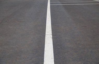 Gri asfalt üzerindeki yol işaretlerinin resmi