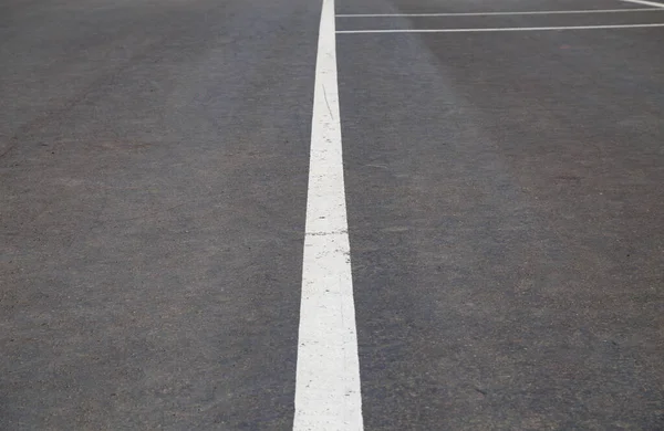 Gri asfalt üzerindeki yol işaretlerinin resmi