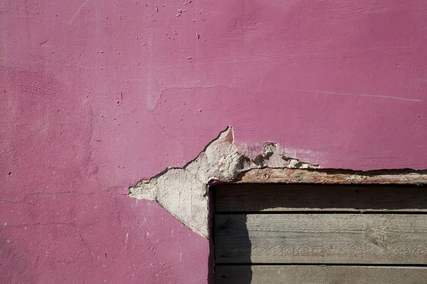 Foto de parede velha com descascamento de tinta rosa — Fotografia de Stock