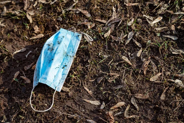 Foto van gebruikt beschermend medisch masker op de grond — Stockfoto