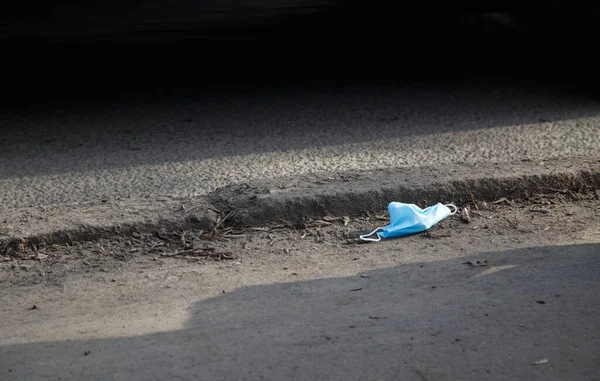 Foto van gebruikt beschermmasker op de onverharde weg — Stockfoto