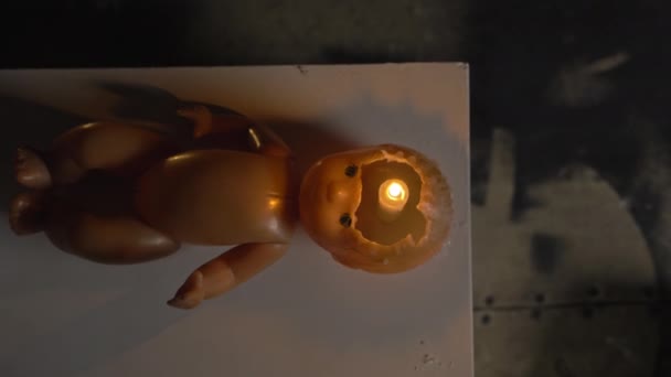 Střelba muže se svíčkou v rozbité panenky hlava — Stock video