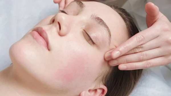 Strzelanie do kobiety dostaje kurs masażu twarzy w salonie — Zdjęcie stockowe