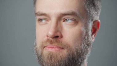 Aylaklık eden sakallı adamın aşırı yakın plan fotoğrafı.