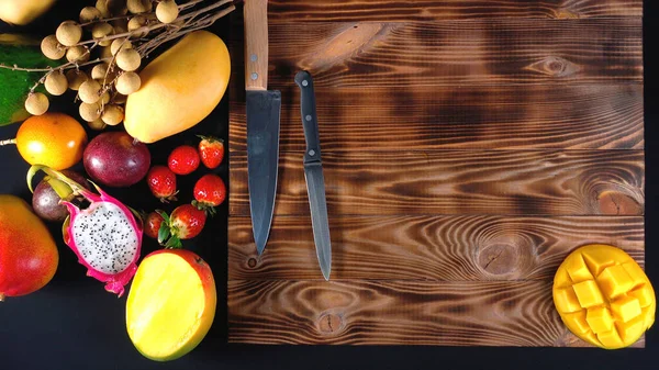 Foto de frutas exóticas en tablero de madera, vista superior — Foto de Stock