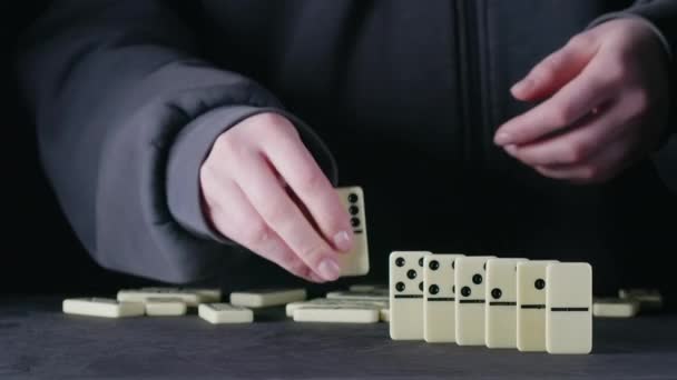 Filmati di donna che posiziona elementi domino sul nero — Video Stock