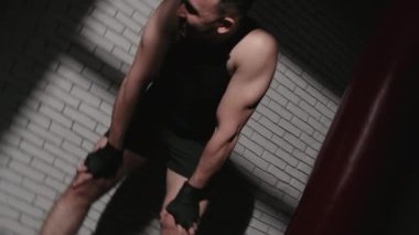 Gölgelerde bandajlı yorgun adamın videosu.