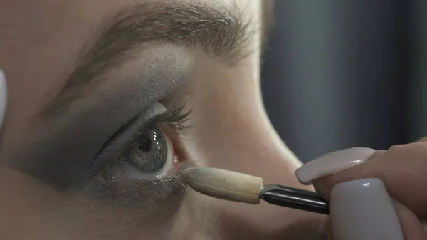 Foto de maestro aplicando sombras oscuras en los ojos —  Fotos de Stock