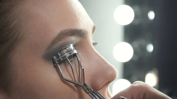 Foto de maestro usando rizador de pestañas en los ojos —  Fotos de Stock