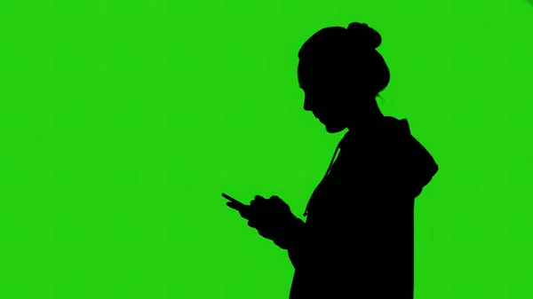 Silueta para niñas con smartphone sobre fondo verde — Foto de Stock