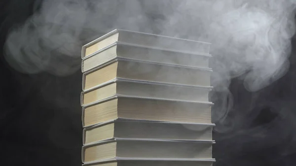 Libros y humo blanco sobre fondo negro — Foto de Stock