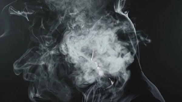 Чоловік в чорному капюшоні з димом всередині — стокове фото