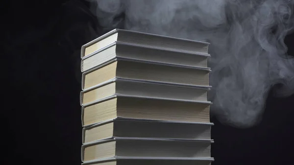 Libros y humo blanco sobre fondo negro — Foto de Stock