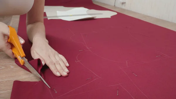 Photo seamstress cutting pattern on fabric in workshop — стоковое фото