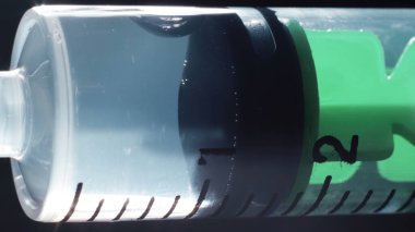 Temiz aşıyla tıbbi şırınganın yakın plan fotoğrafı.