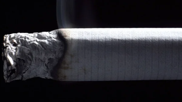 Πυροβολισμός τσιγάρου που σιγοκαίει στη σκιά σε μαύρο — Φωτογραφία Αρχείου