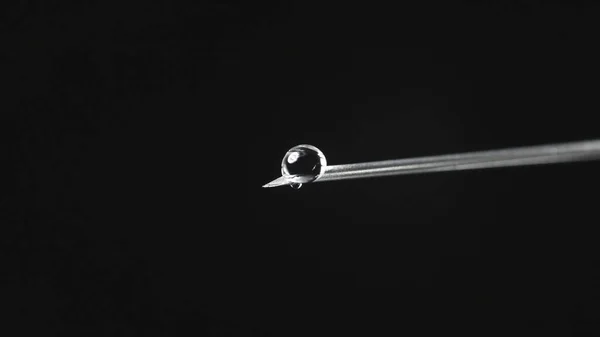 Foto de aguja de jeringa con gota de solución transparente — Foto de Stock