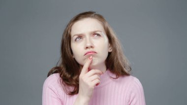 Pembe balıkçı yaka yakalı düşünceli bir kadının fotoğrafı.