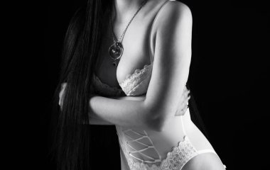 Siyah beyaz kadın, kolları çaprazlanmış beyaz iç çamaşırlı.