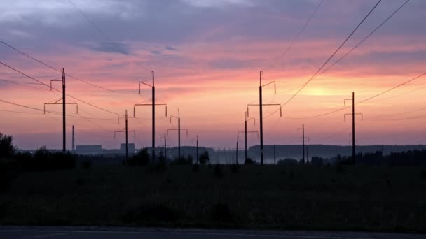 Автомобіль та лінія електропередач на фоні заходу сонця — стокове відео