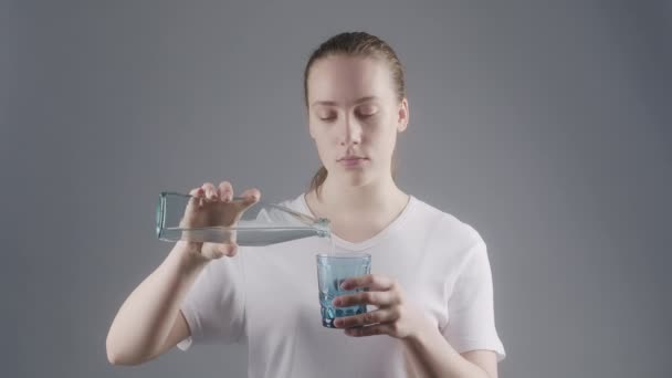 Beelden van een vrouw die mineraalwater in glas giet — Stockvideo
