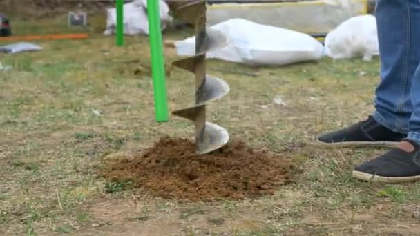 Schieten van een handbediende ijzeren boor op de grond — Stockvideo