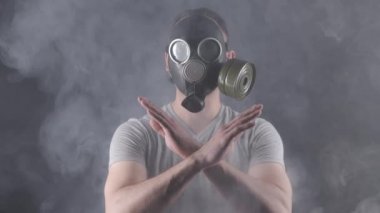 Gaz maskeli bir adamın dur işareti yaptığı video.