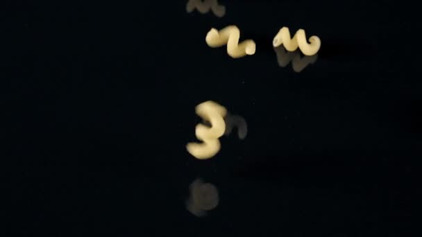 Vallende spiraal pasta op zwarte achtergrond — Stockvideo