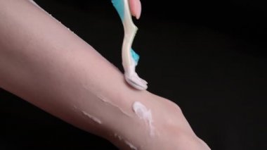 Bacaklarını tıraş eden bir kızın görüntüsü.