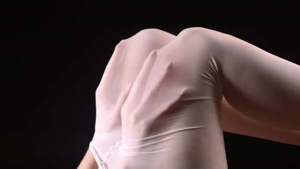 Πλάνα με γυναικεία χέρια κάτω από λευκό καλσόν — Αρχείο Βίντεο