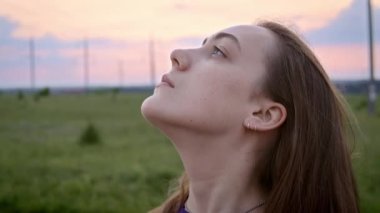 Gün batımında kırsalda dinlenen bir kadının portresi.