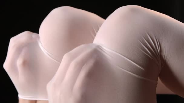 Tir de mains féminines sous des collants en nylon — Video