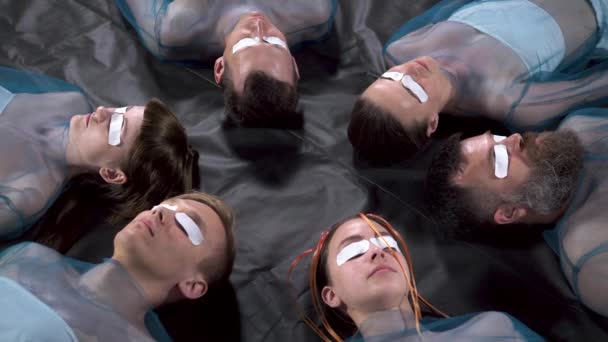 Видео о лежащих мужчинах и женщинах с пластырями на глазах — стоковое видео