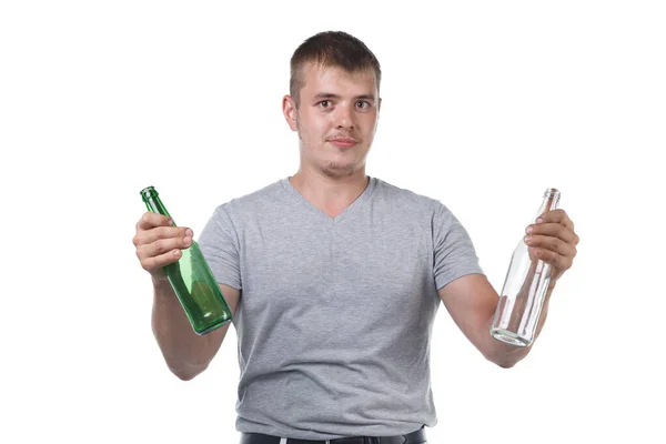 Image of young man with bristle holding empty glass bottles — Stock Photo, Image