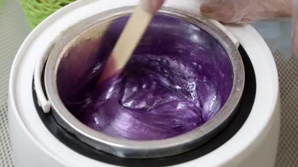Cera violeta derretida y palo de madera para depilación — Vídeos de Stock