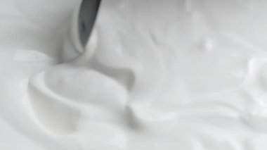 Kremalı ve daldırılmış kaşıkla yakın çekim.