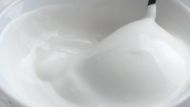 Aufnahme von Schüssel mit gerührtem Joghurt und Löffel — Stockvideo