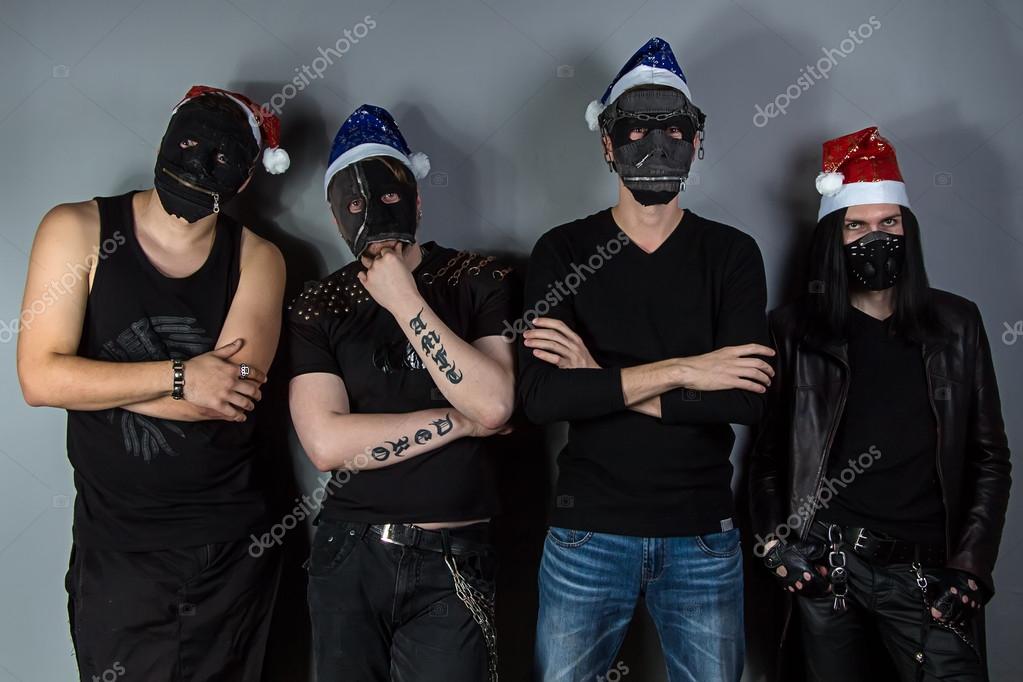 Mans metal band in christmas hats and masks — Stock Photo © ChrisTefme