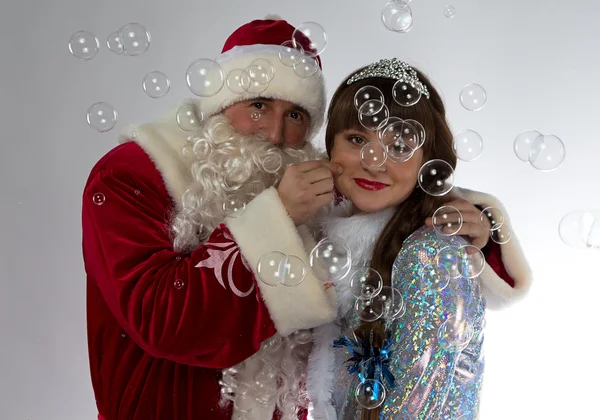 Foto van Santa en sneeuw maiden met zeepbellen — Stockfoto