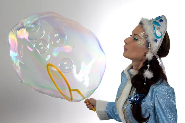 Photo of cute snow maiden blowing soap bubbles — Stock Photo, Image
