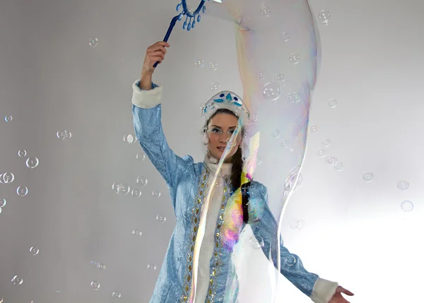 Image of snow maiden looking at soap bubbles — Stock Photo, Image