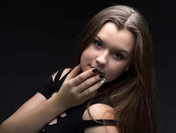 Image of girl in black dress with hand near mouth — Stock Photo, Image