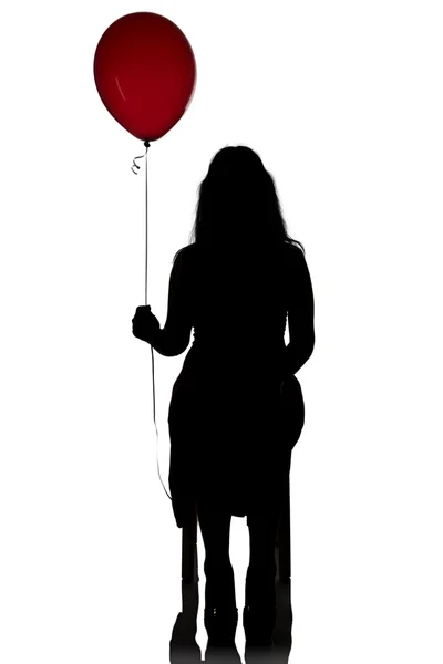 Foto sentado silueta de las mujeres con globo rojo — Foto de Stock