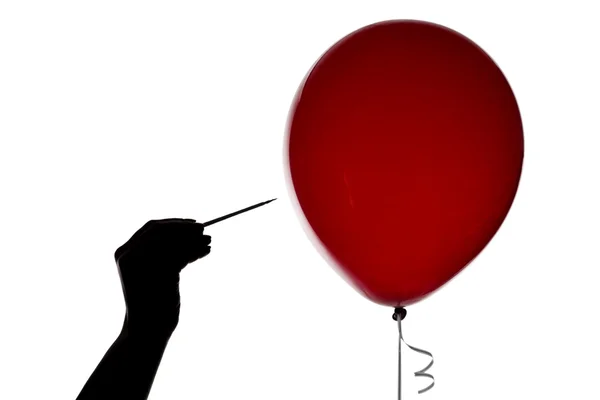 Silhouette of hand with the needle and red balloon — Stock Photo, Image